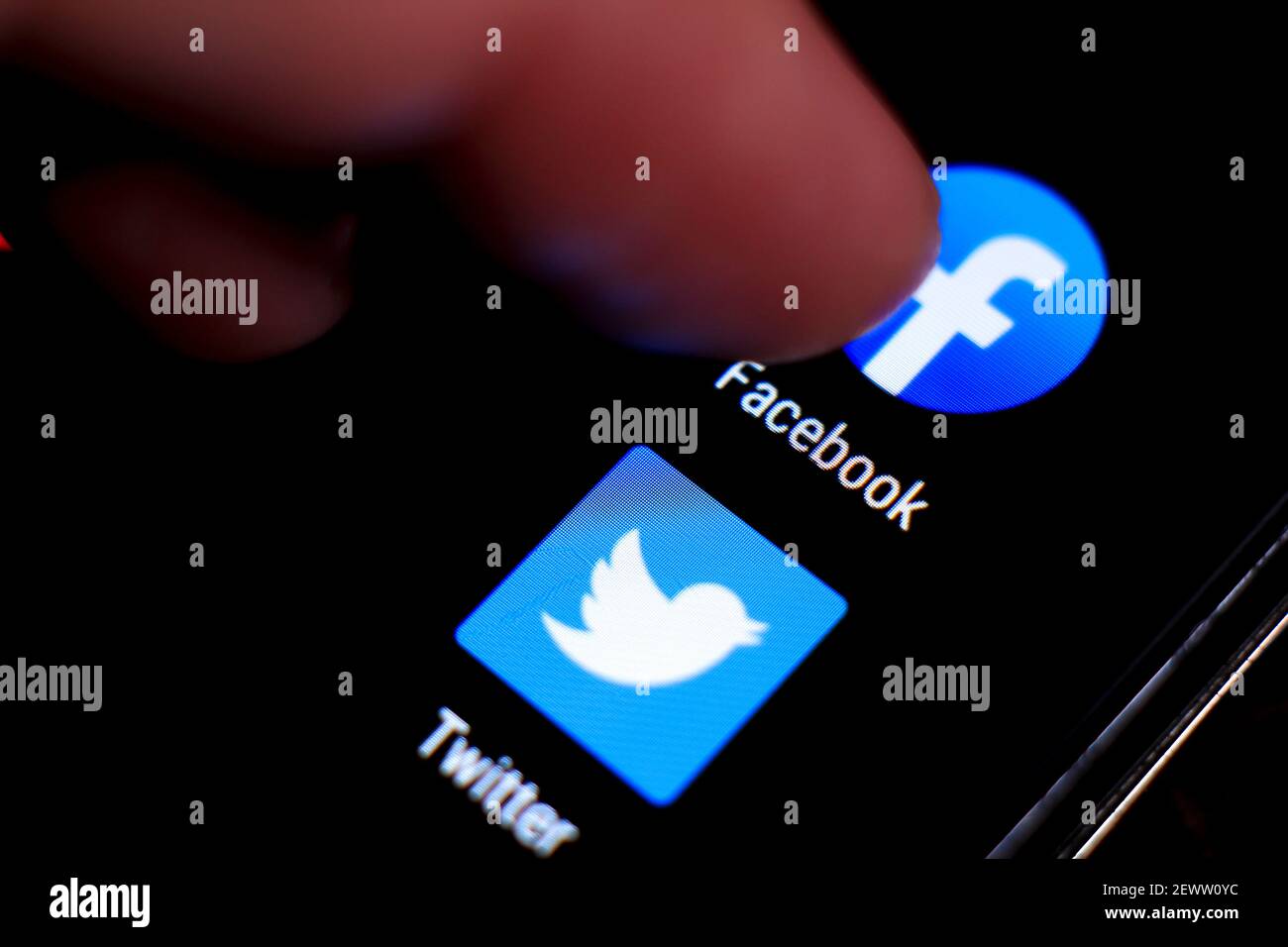 Madrid Spain March 3 21 Finger Pressing Facebook Icon On Black Mobile Phone Screen Twitter Icon In The Background Stock Photo Alamy