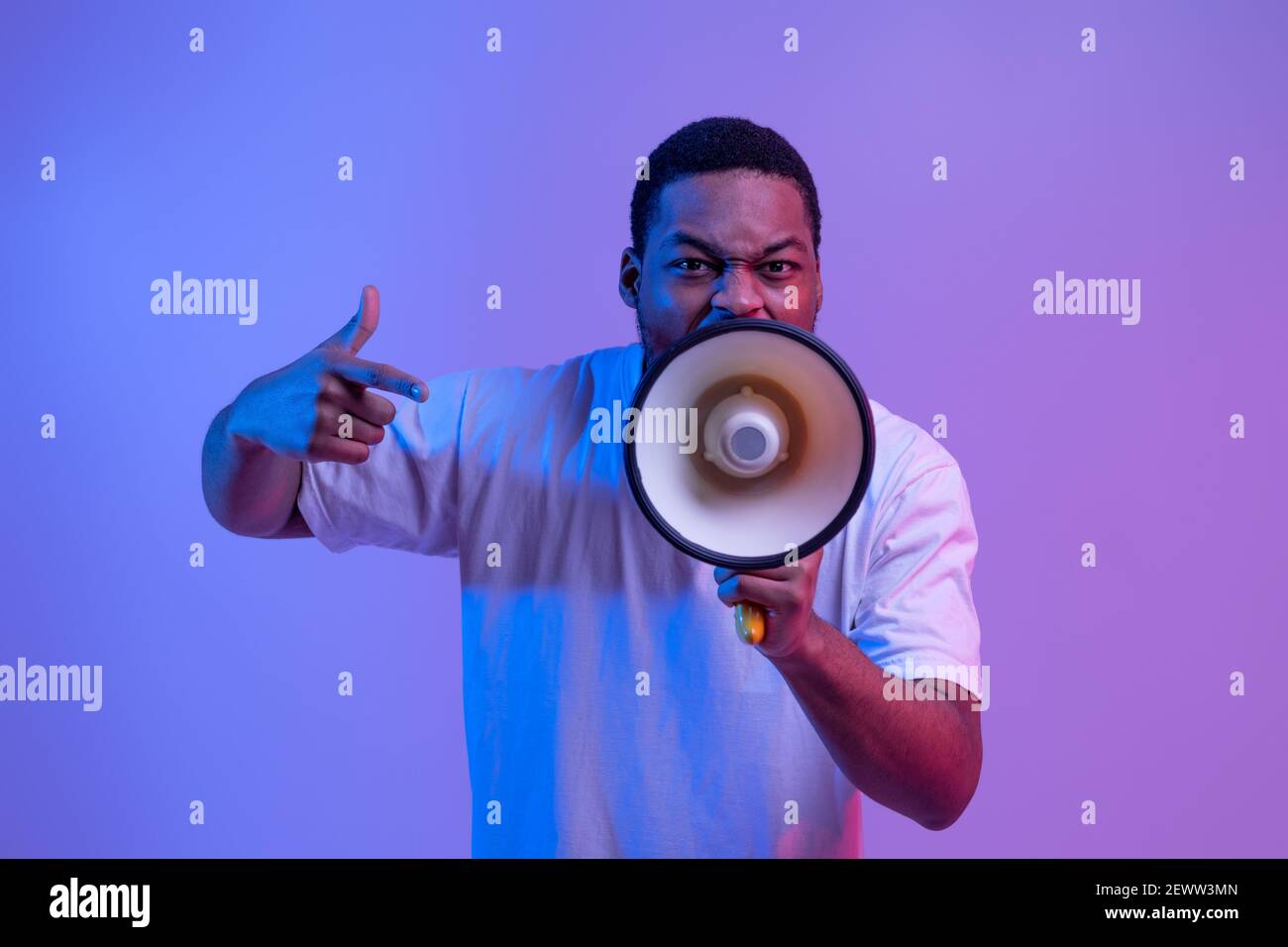 Agressive Black Guy Shouting Into Loudspeaker, Making Announcement And Emotionally Gesturing Stock Photo
