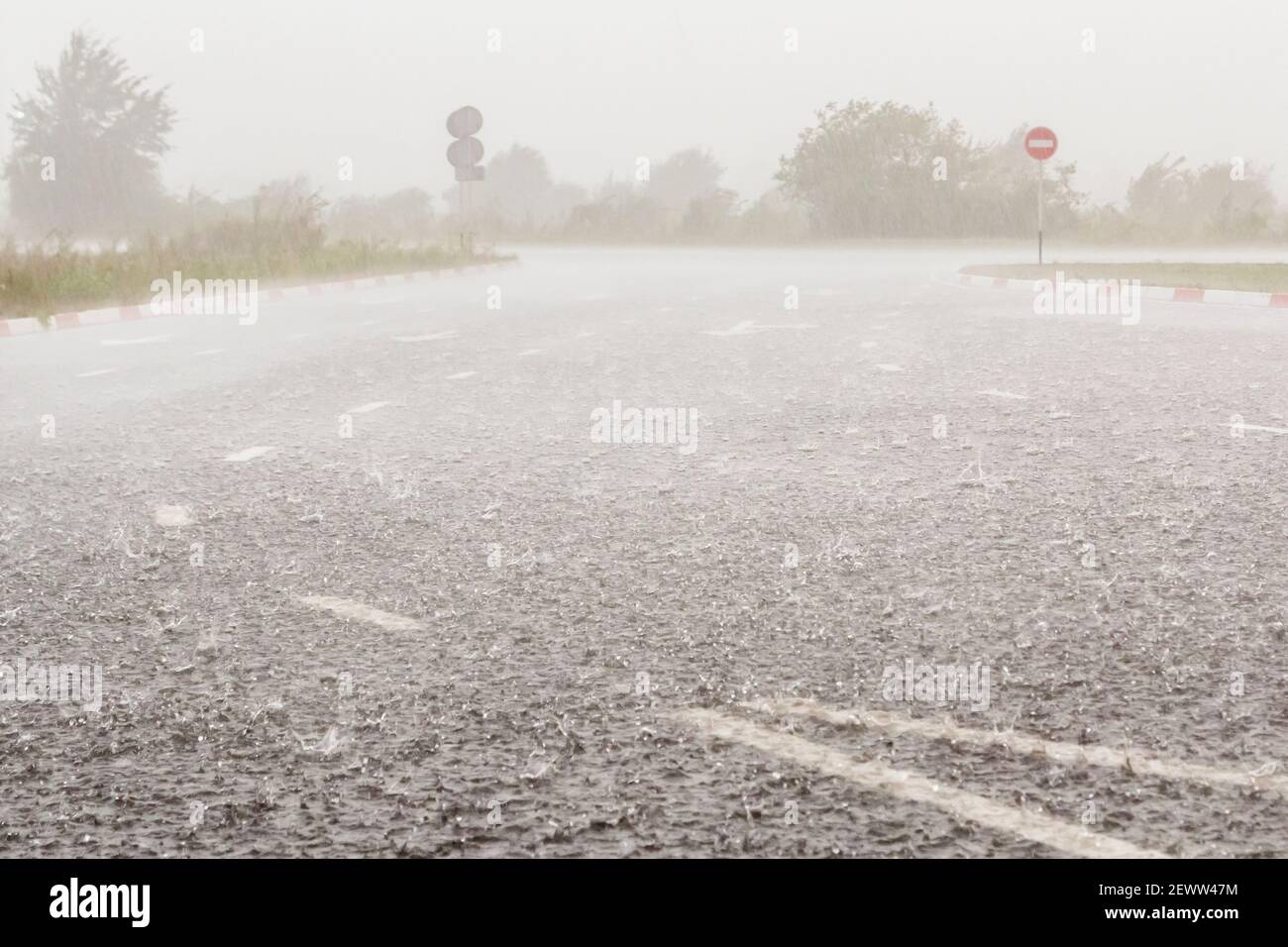 Heavy rain with hail is falling along the highway. Large drops with