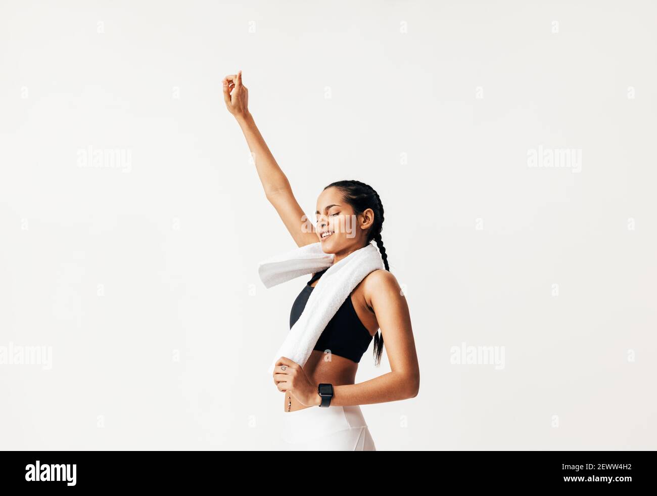 Female athlete with closed eyes jumping against white background Stock