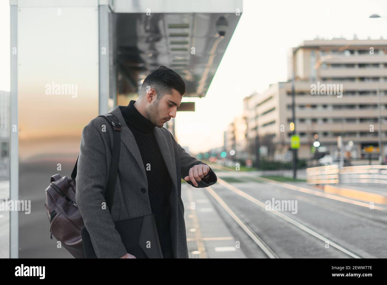 Young businessman waiting for train looking at his watch. Stock Photo