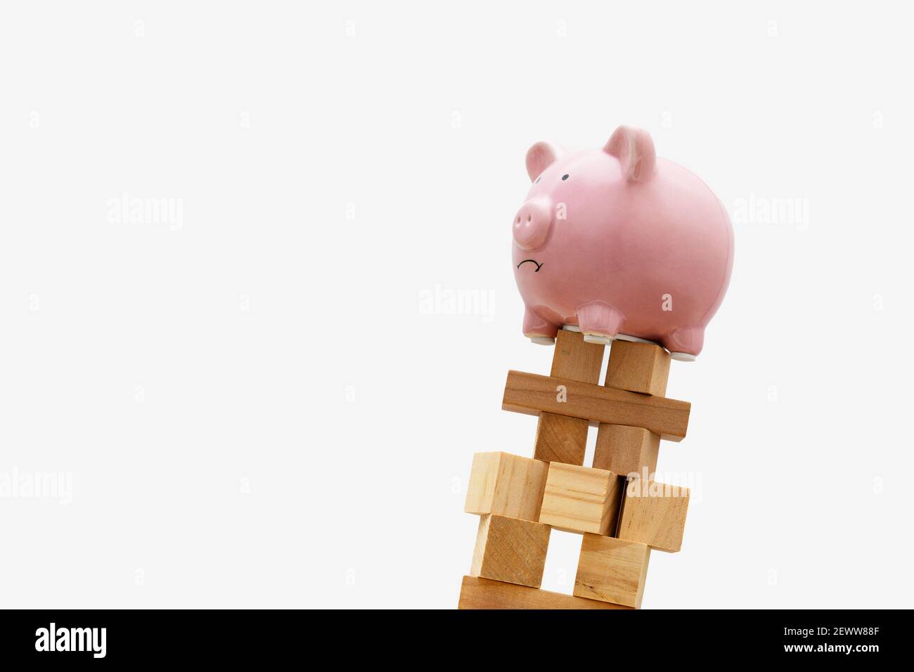 Piggy Bank on Falling Wood Block Tower. Financial Crash Concept. Stock Photo