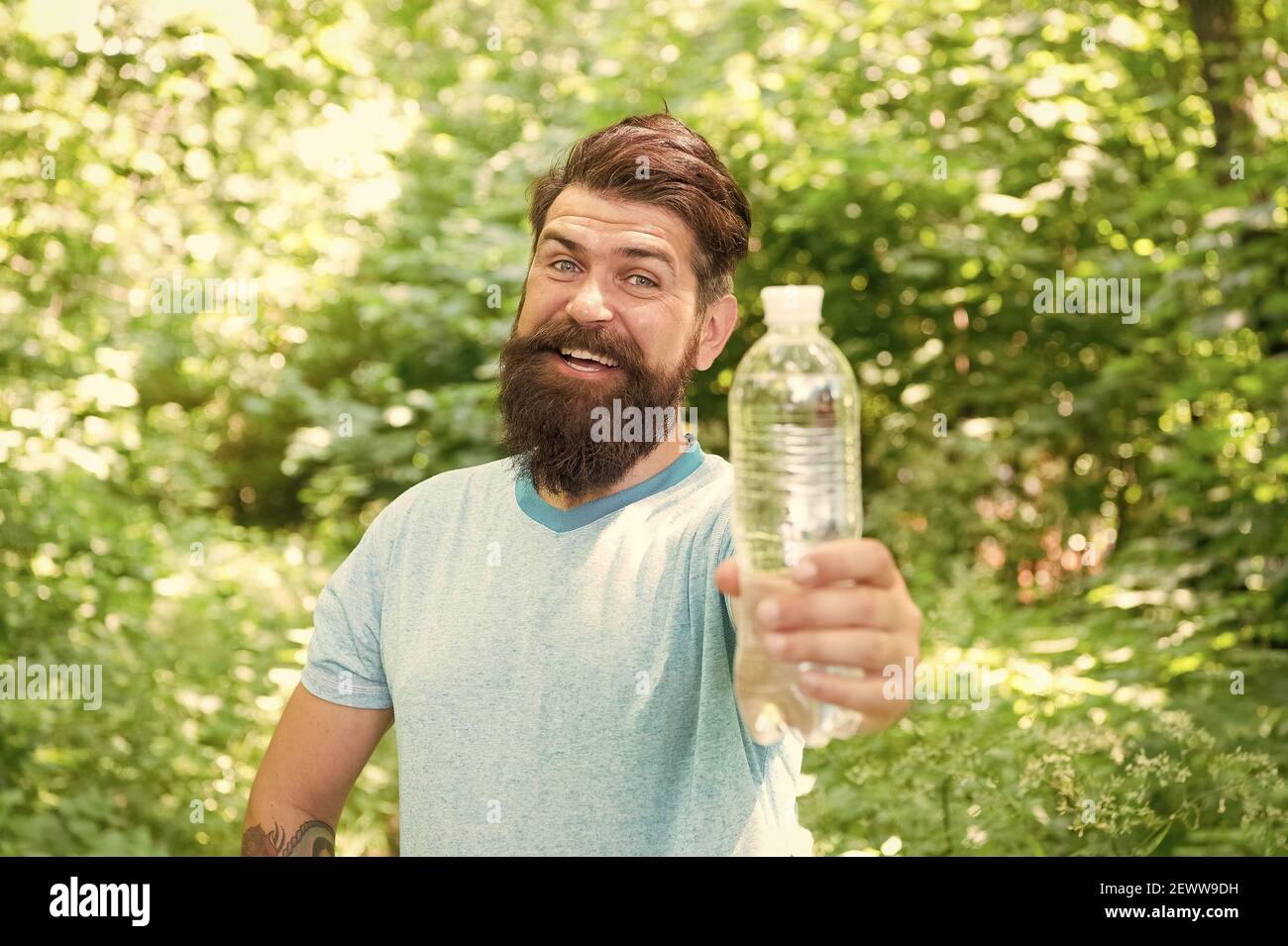 Drink Plenty Of Water. drinking water in forest outdoor with sunset nature on background. Bearded man with water bottle. fitness portrait of bearded man. happy mature guy. thirsty hipster traveler. Stock Photo