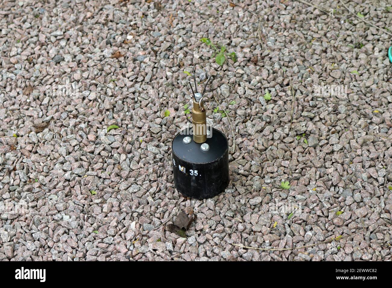 German world war two S MI 35 anti personnel mine, or bouncing betty at a historic reenactment event on a background of gravel chips. Stock Photo