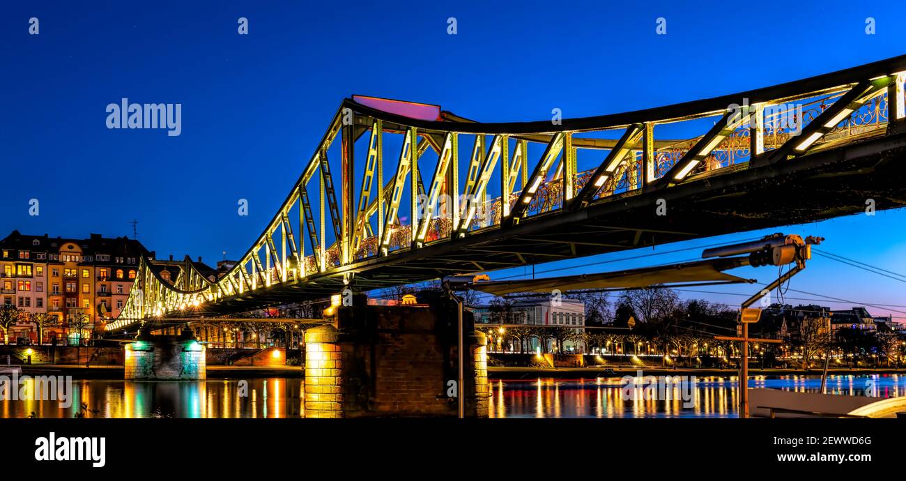 Panorama of the Eiserner Steg bridge at blue hour in Frankfurt am Main, Germany Stock Photo