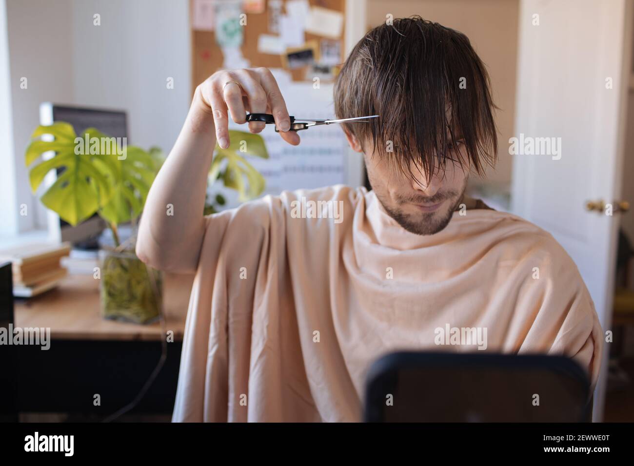 Home haircut. Man cutting hair at home. Life in pandemic during lockdown. How to cut your own Hair when hairdressers are closed. Easiest Self-haircut Stock Photo
