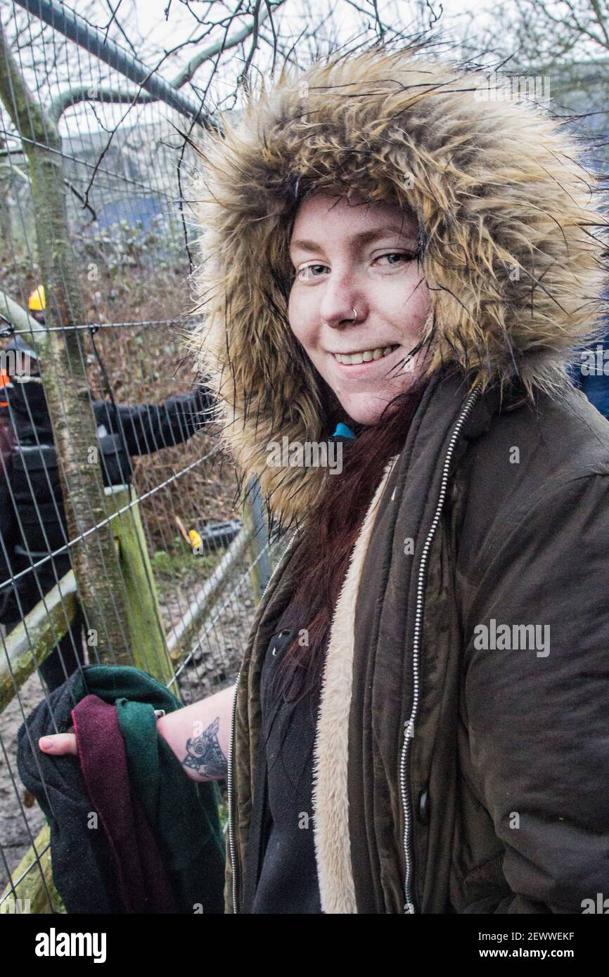 Old Oak Lane, London, UK. 3rd March, 2021. Melody smiles to the camera while locked to a fence settled by HS2 to delimitate territoriality. In the early morning of 3rd of March, environmentalists have set a protection camp to stop the HS2 construction works in the natural reserve of Wormwood Scrubs, site of importance for nature conservation (SINC). Locals state that HS2 has “quietly pushed through planning proposals' to begin construction works and 24 hour tunnelling in order to divert the Stamford Brook sewer line across the reserve. Sabrina Merolla/Alamy Stock Photo