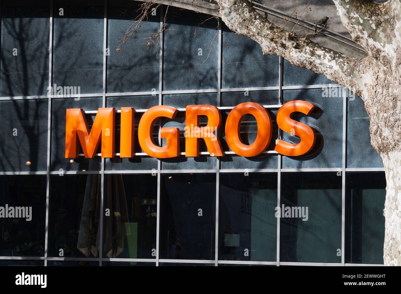 Bellinzona, Ticino, Switzerland - 25th February 2021 : Migros supermarket logo hanging in front of a store in Bellinzona. Migros company is the bigges Stock Photo