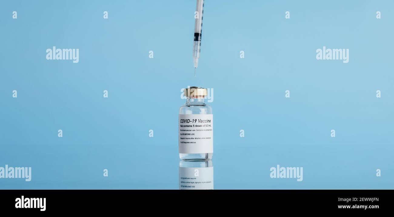 Vial with a syringe on reflective surface. Corona virus vaccine with ...
