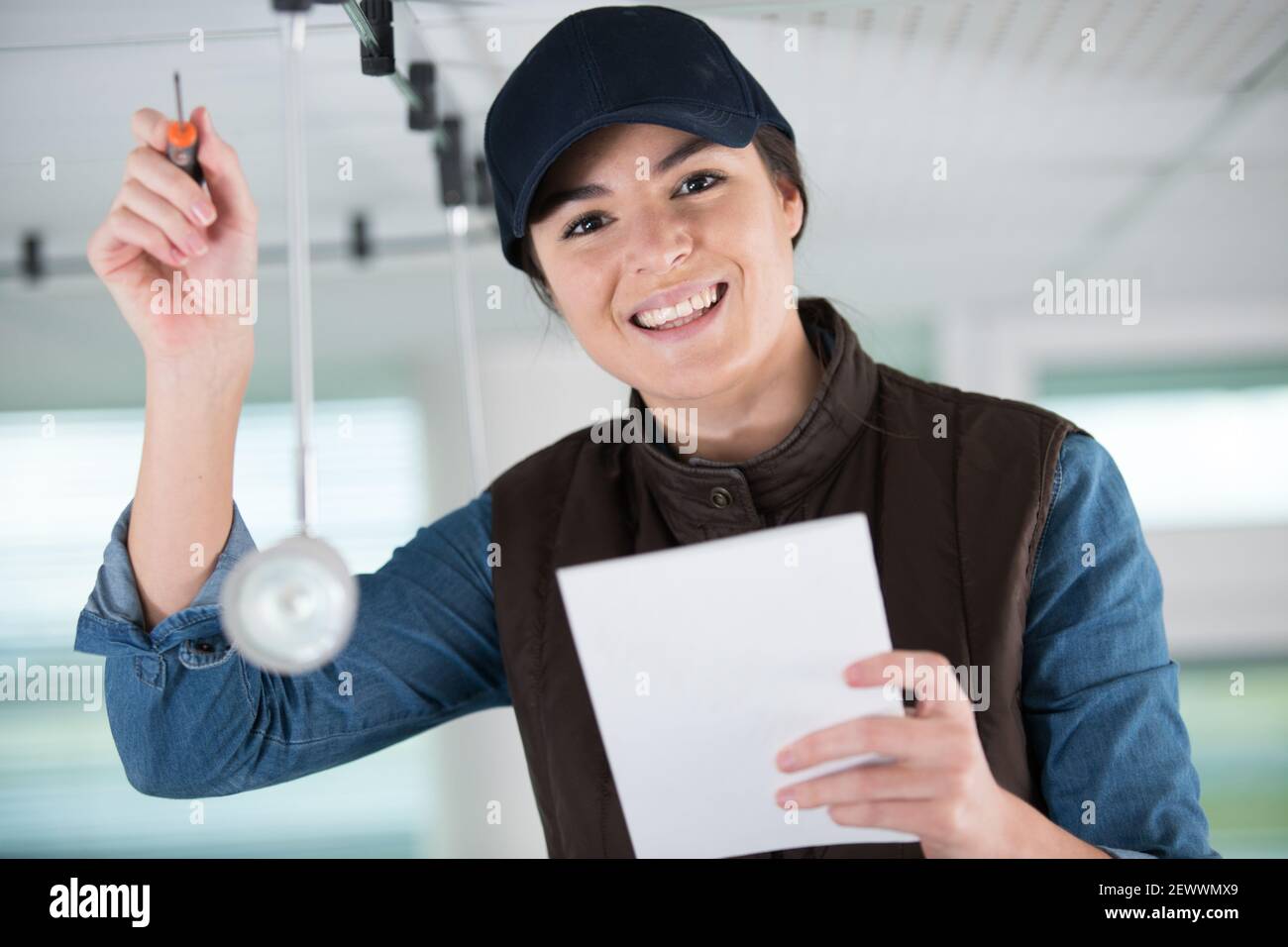 female worker screwing something in the ceiling Stock Photo - Alamy