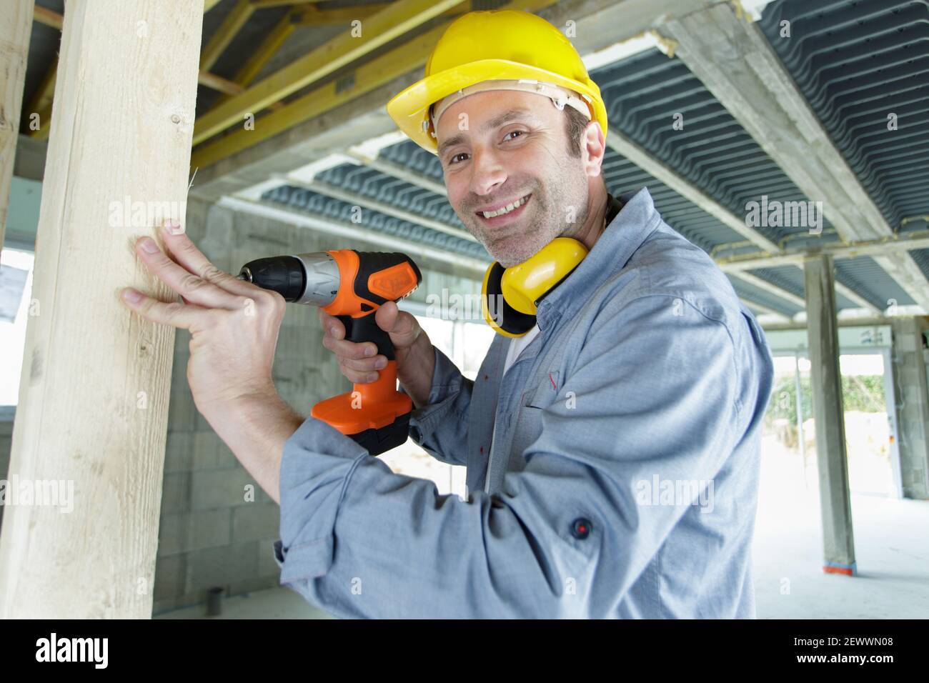 happy builder is holding a drill Stock Photo