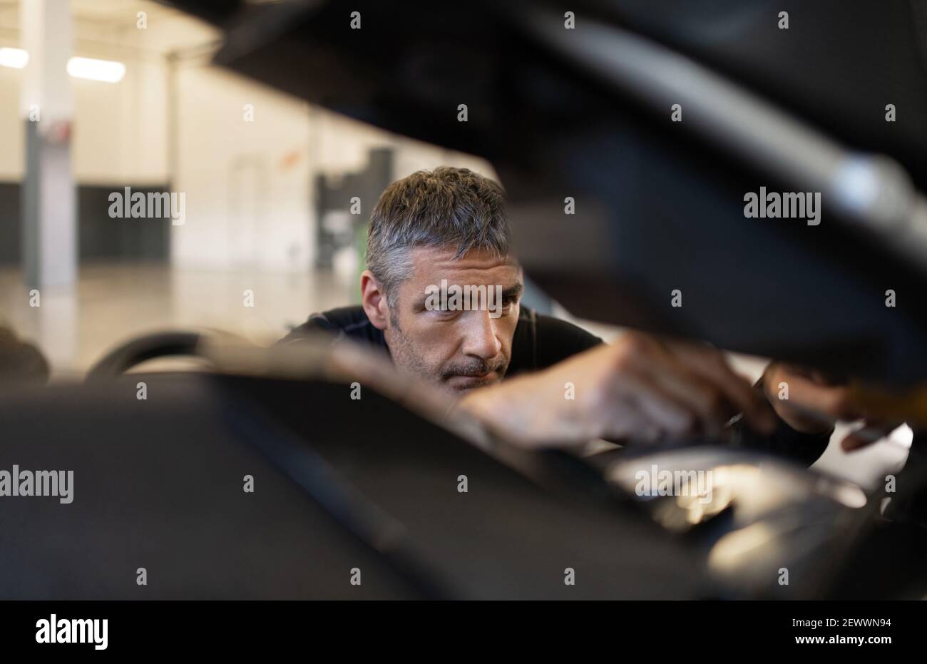 Mature male mechanic fixing motorcycle Stock Photo