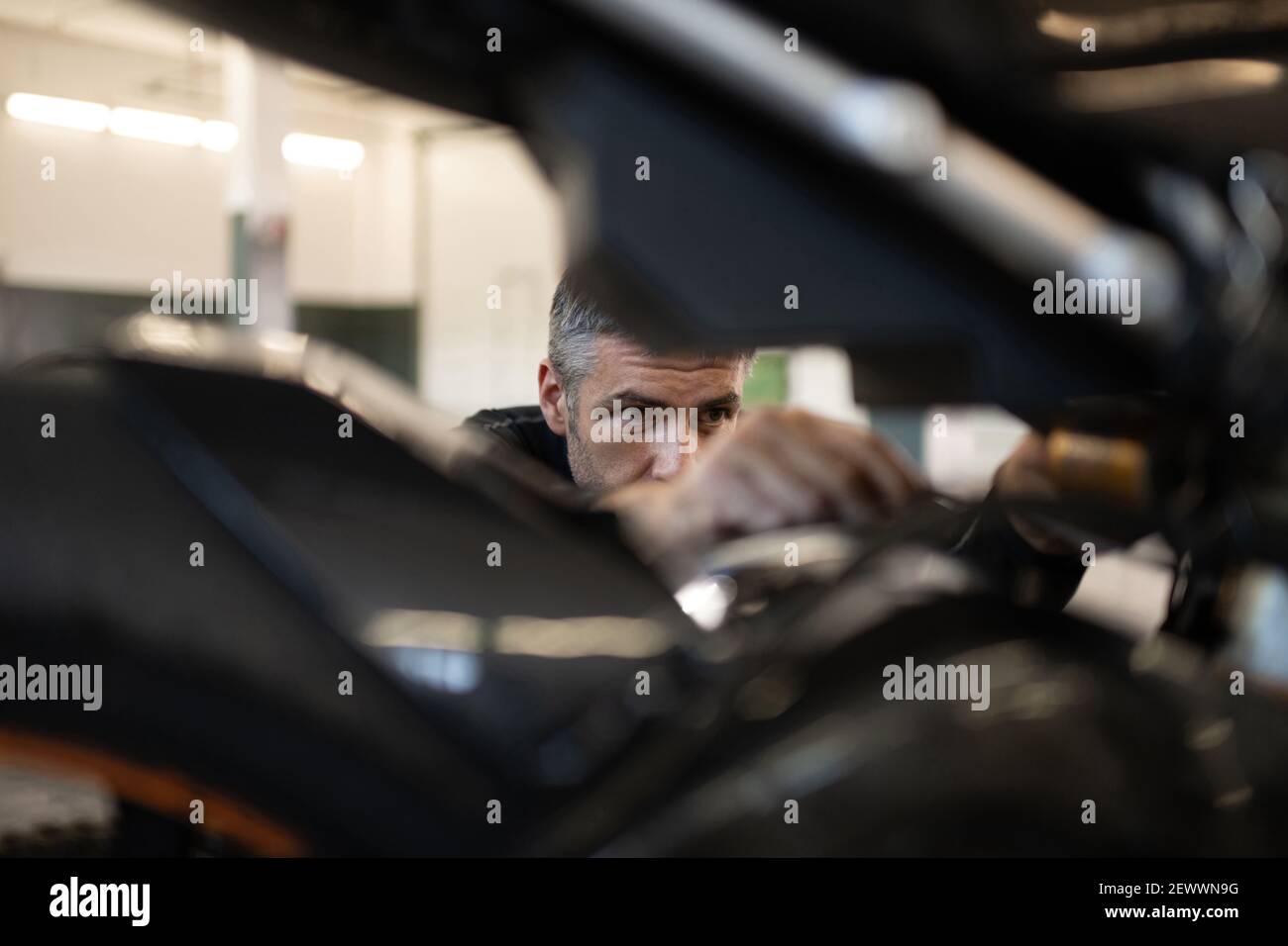 Focused mechanic fixing motorbike in garage Stock Photo