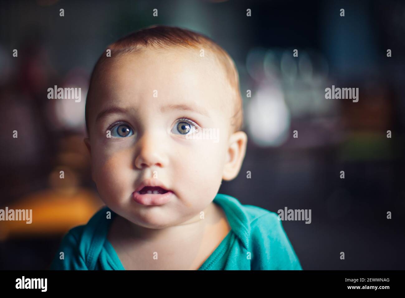 Baby with hazel eyes and green onesie Stock Photo Alamy