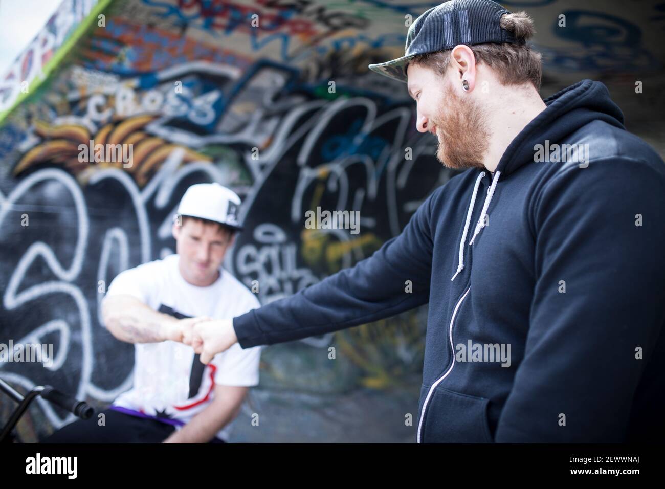 Two buddies bmxing and giving eachother a handshake Stock Photo
