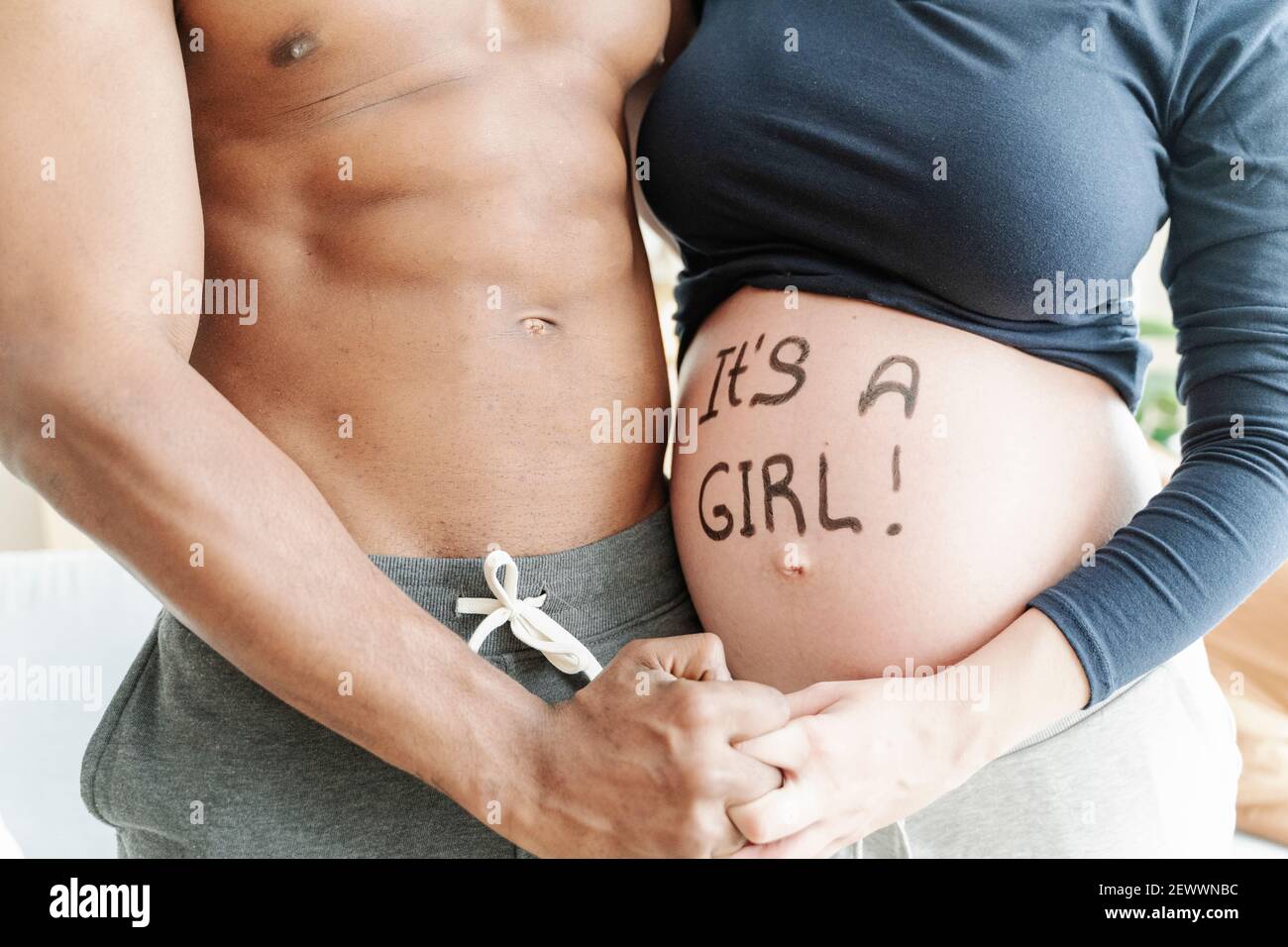 Crop ethnic man and pregnant woman hugging at home Stock Photo - Alamy