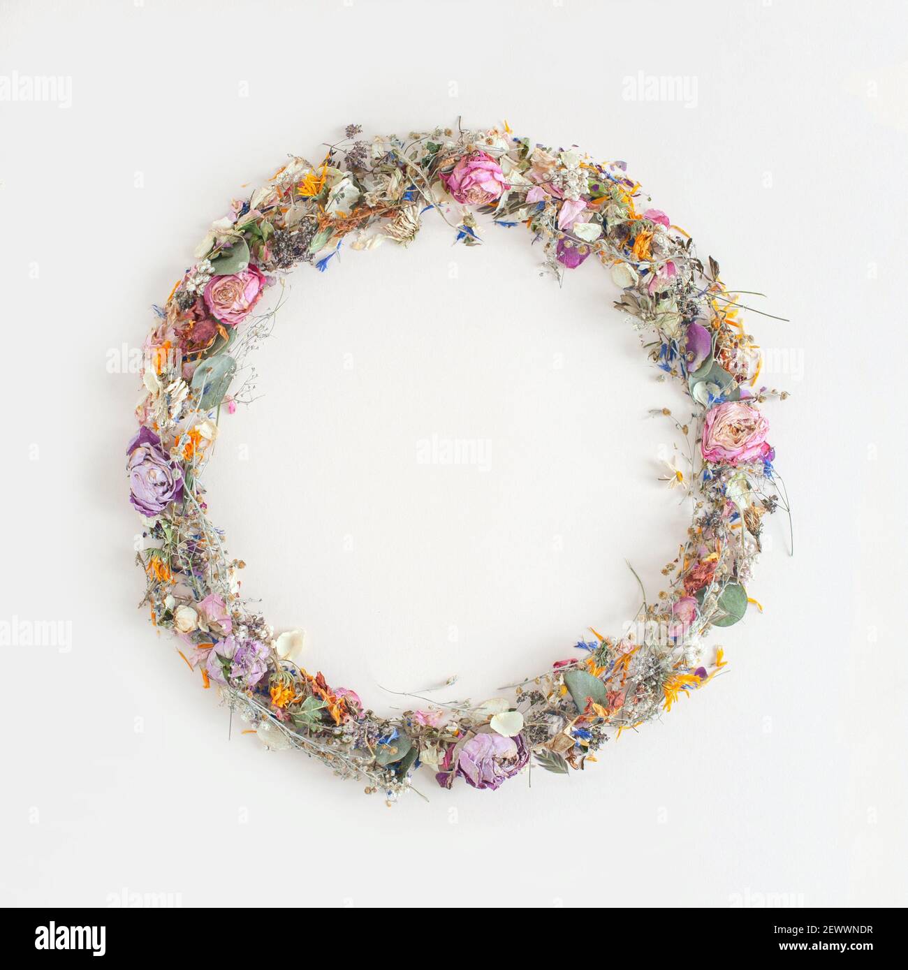 Creative round frame made with summer dried wild natural flowers and leaves over white background. Vintage nature pattern art Stock Photo