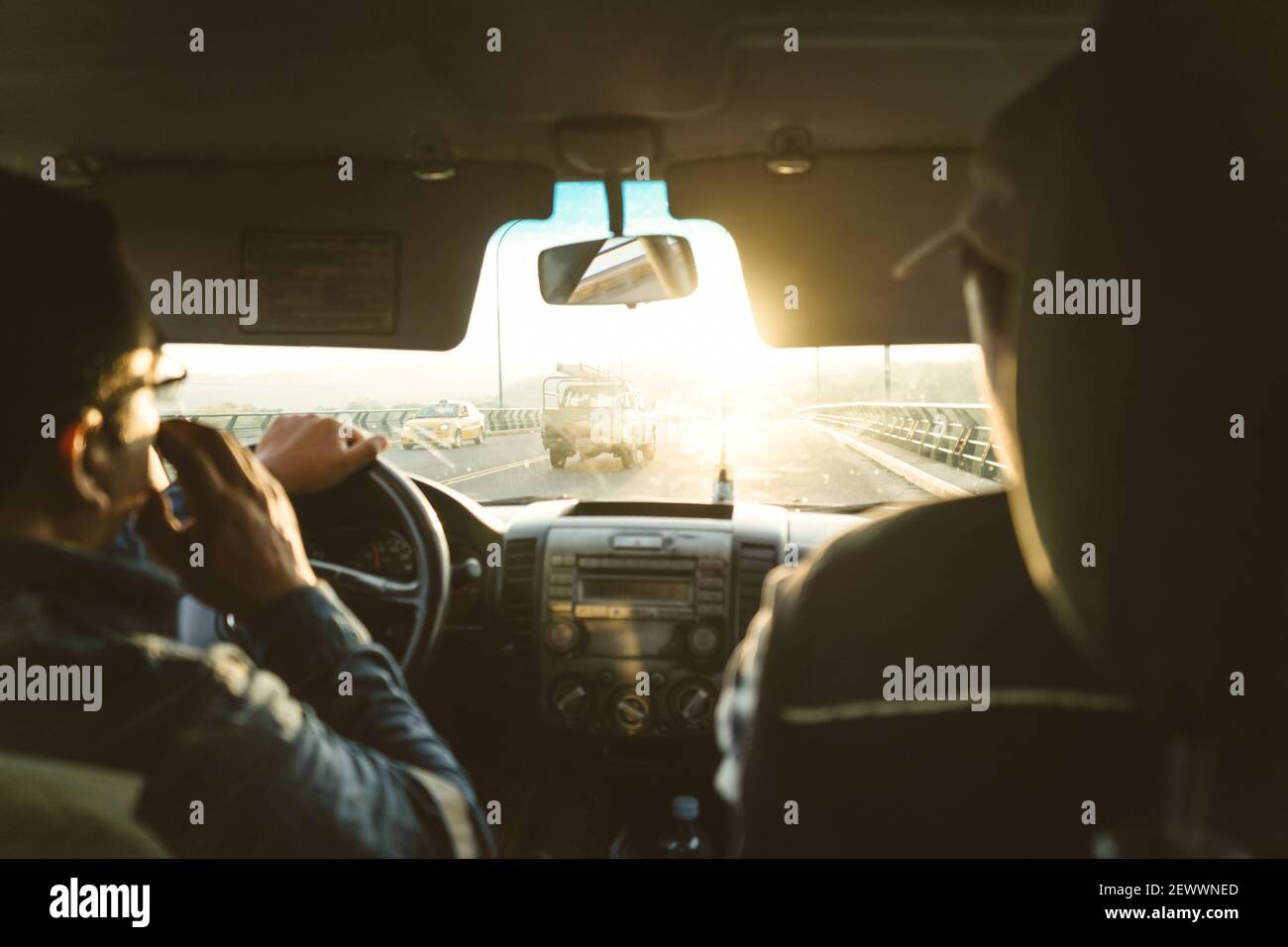 Two engineers inside a car going to work in the sunrise Stock Photo