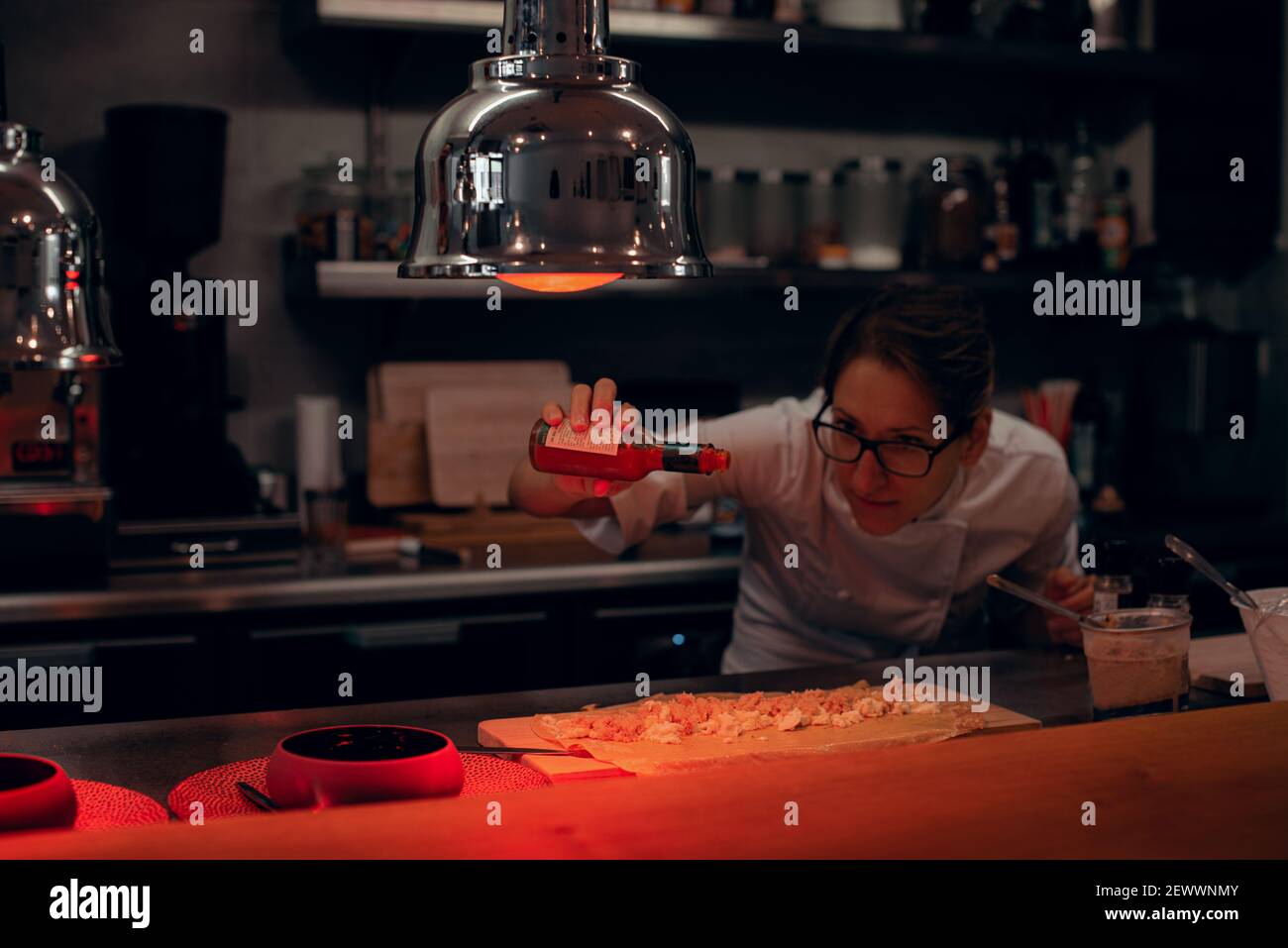 https://c8.alamy.com/comp/2EWWNMY/chef-preparing-food-while-working-with-heat-lamps-in-restaurant-2EWWNMY.jpg
