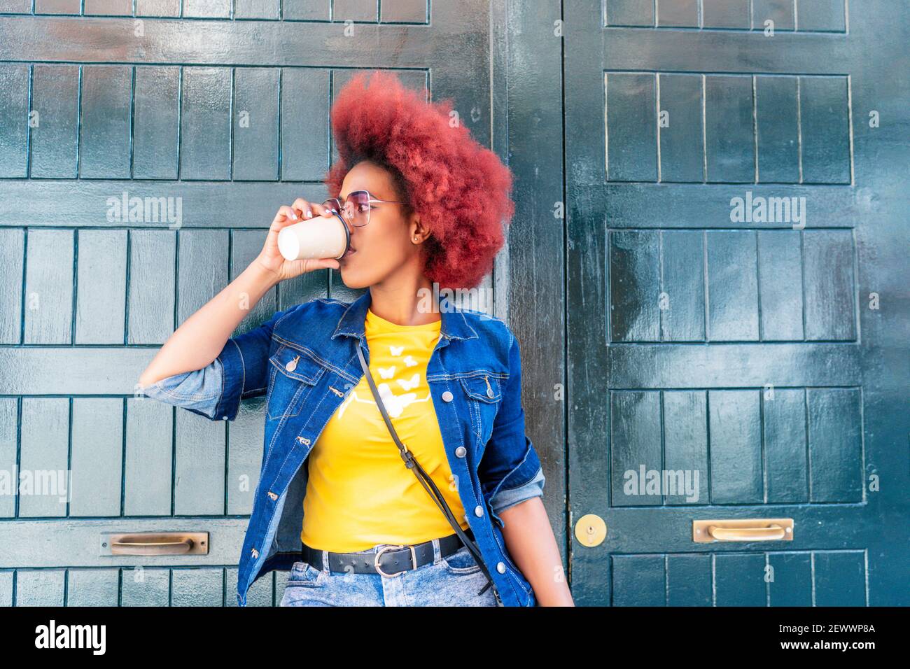 woman with red afro hair having a cup of coffee Stock Photo