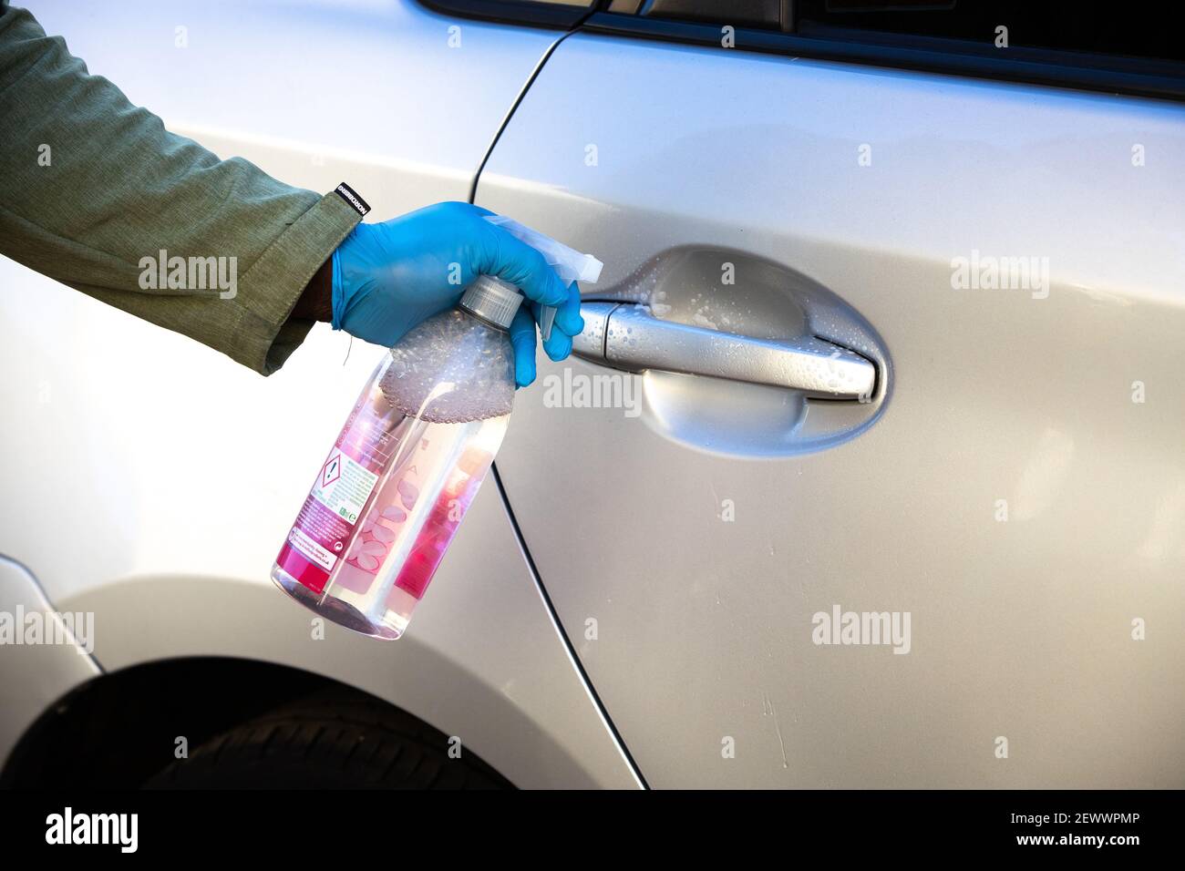 A private hire driver deep cleans his car with disinfectant after