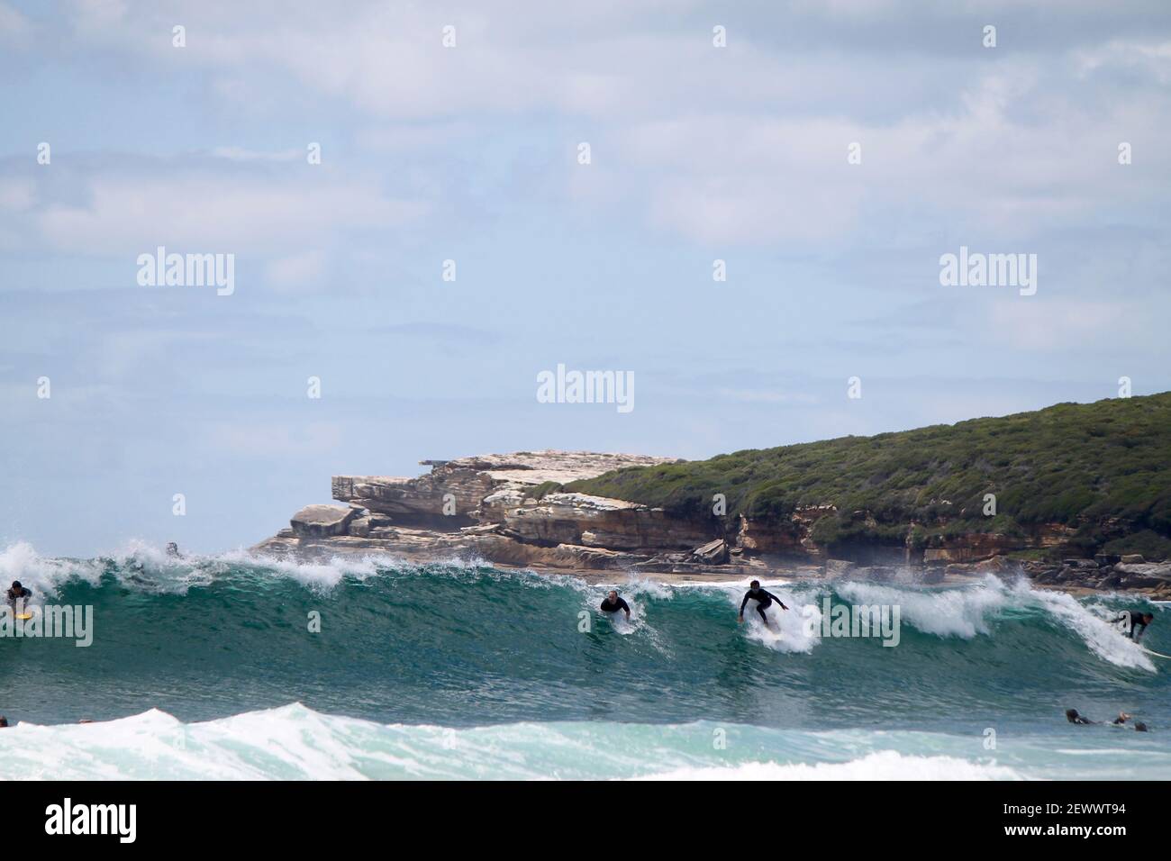 Acrobatic Surfers on the turquoise wave of Maroubra beach near sydney. One surfer got the priority and the one at his right shouldn't go... Stock Photo