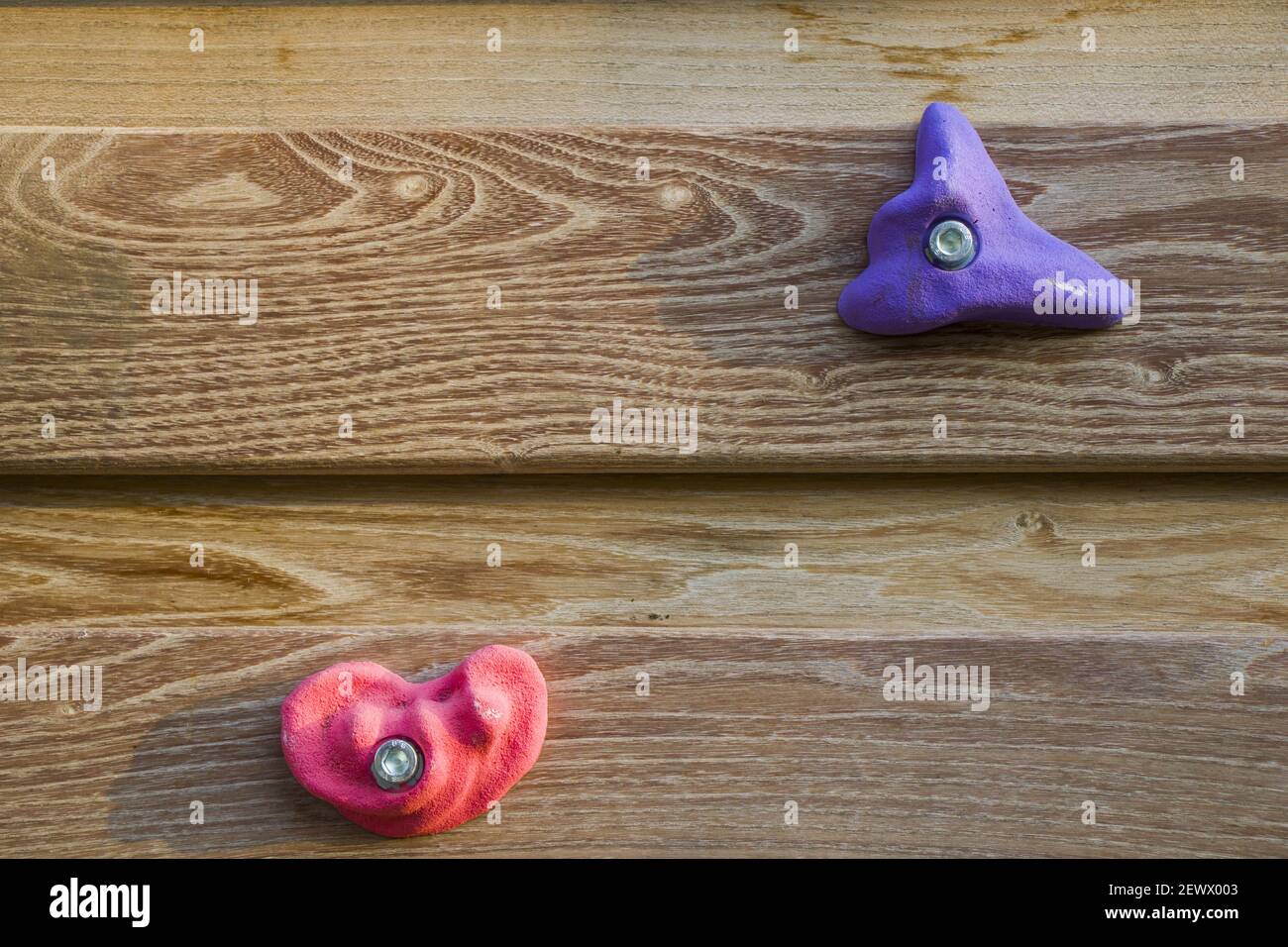 A closeup shot of a climbing wall withcolorful hanging rocks isolated on the wooden material Stock Photo