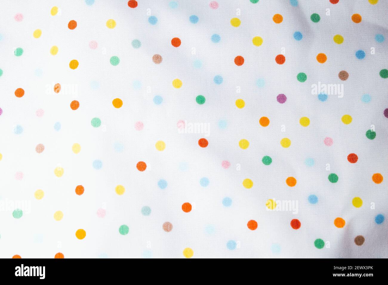 Fabric texture with multi-colored circles. Fabric background with pattern. Rainbow balls on the fabric. Stock Photo