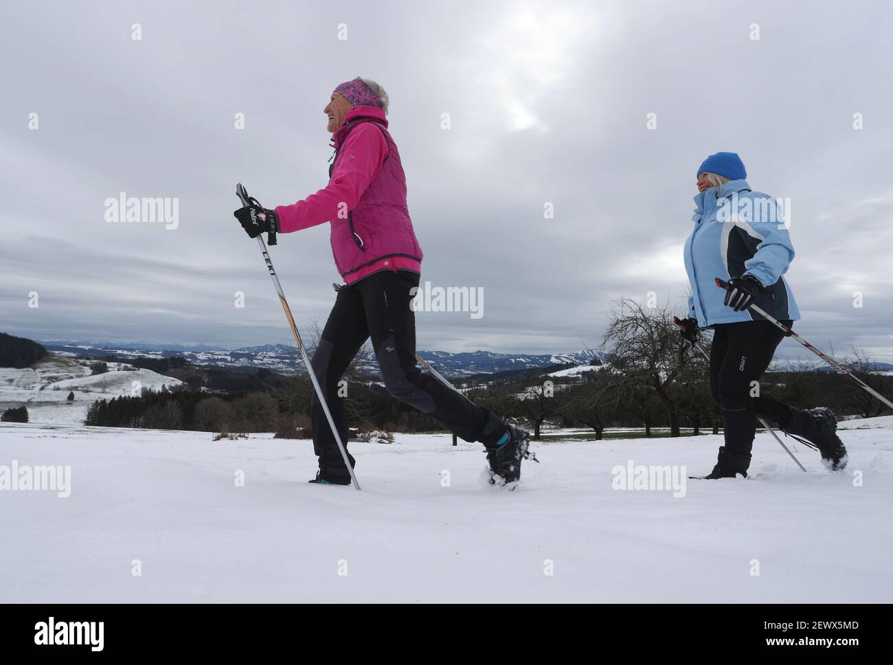 Wiggensbach, Germany. 16th Feb, 2021. Ida-Anna Braun (r), chairwoman of the Kempten Kneipp Association, and Monika Weitnauer, secretary and Nordic walking leader of the association, walk through the snow while Nordic walking in front of the panorama of the Alps. (to dpa 'Kneipp associations fight for image and members in anniversary year') Credit: Karl-Josef Hildenbrand/dpa/Alamy Live News Stock Photo