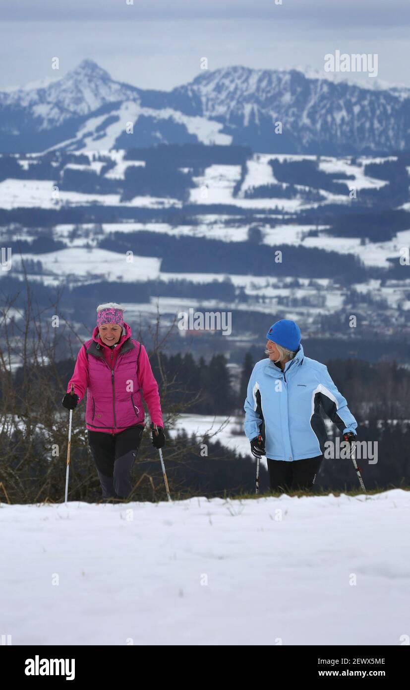 Wiggensbach, Germany. 16th Feb, 2021. Ida-Anna Braun (r), chairwoman of the Kempten Kneipp Association, and Monika Weitnauer, secretary and Nordic walking leader of the association, walk through the snow while Nordic walking in front of the panorama of the Alps. (to dpa 'Kneipp associations fight for image and members in anniversary year') Credit: Karl-Josef Hildenbrand/dpa/Alamy Live News Stock Photo