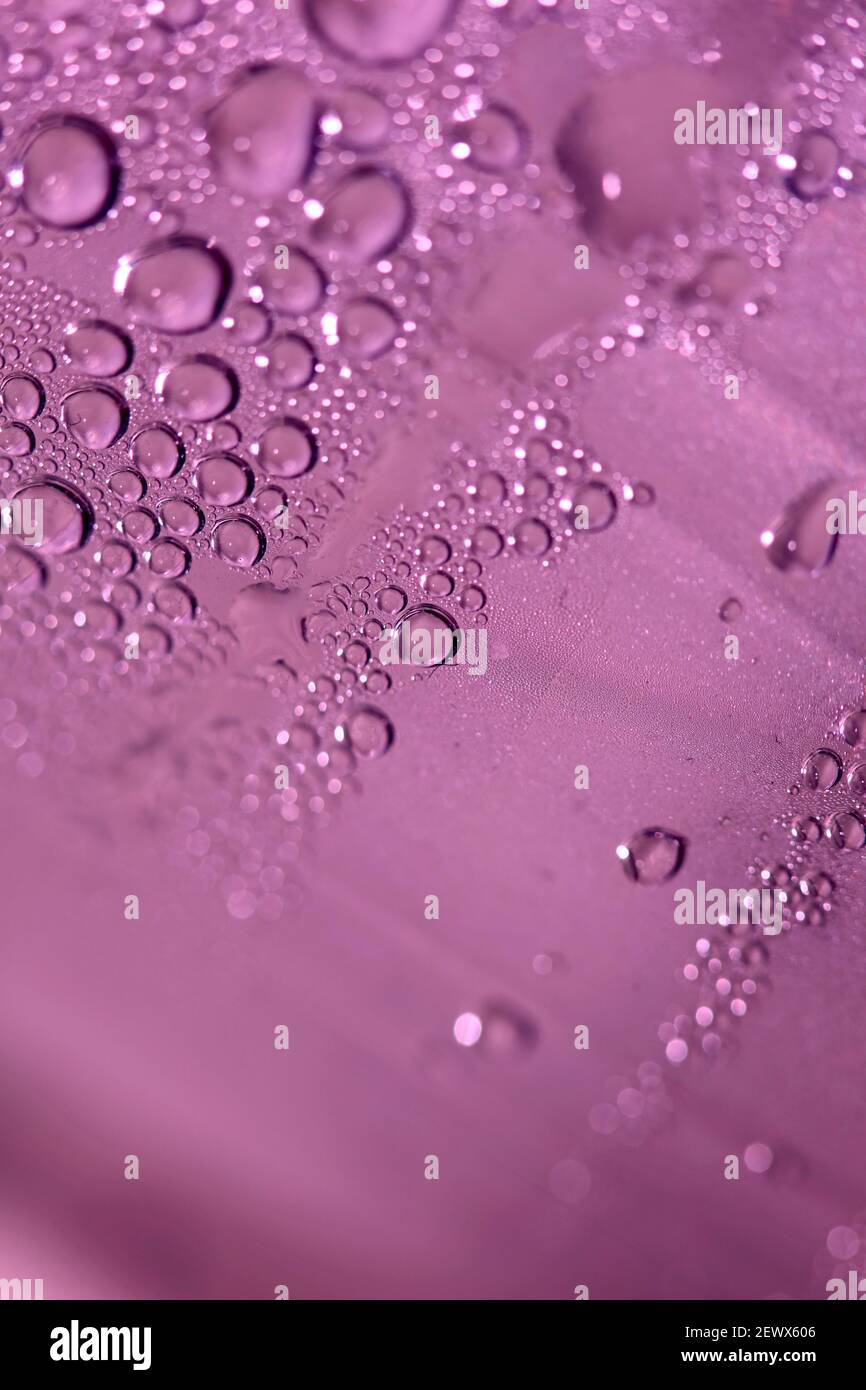 Macro shooting of water droplets beside the glass surface close up ...