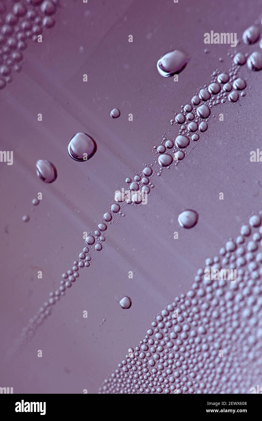 Macro shooting of water droplets beside the glass surface close up ...