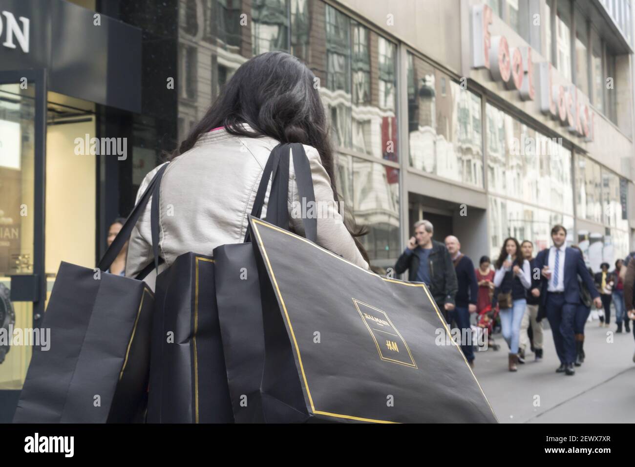 Shoppers leave an H&M store in New York with their Balmain x H&M purchases  on Thursday, November 5, 2015. Qatar's Mayhoola sovereign wealth fund has  purchased the Balmain fashion house for a