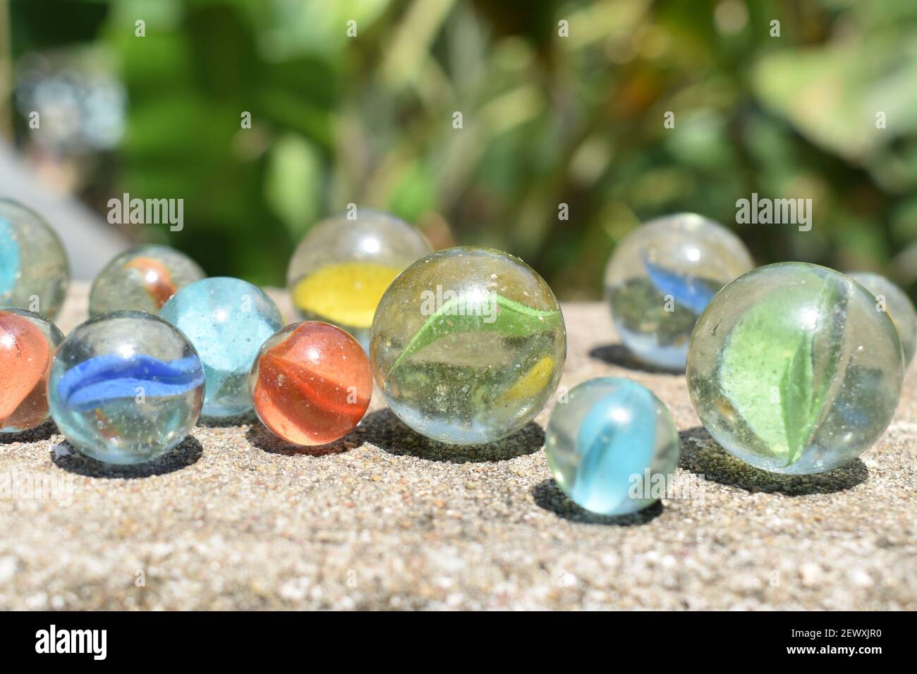 fun game for kids with colored glass marbles, glass balls Stock Photo -  Alamy