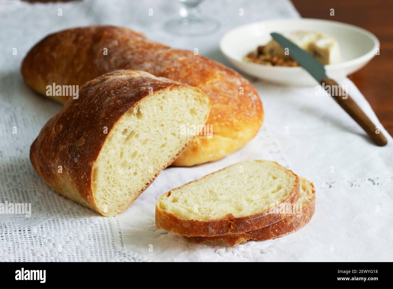 Ciabatta, cheese and nuts on a wooden table. Stock Photo