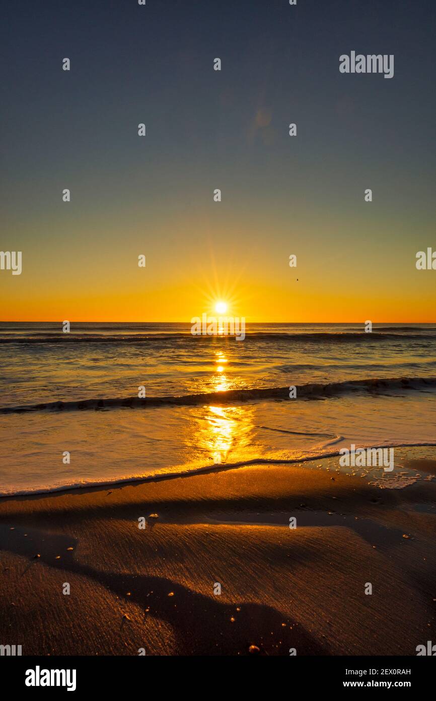 The beach during a nice and calm sunrise Stock Photo