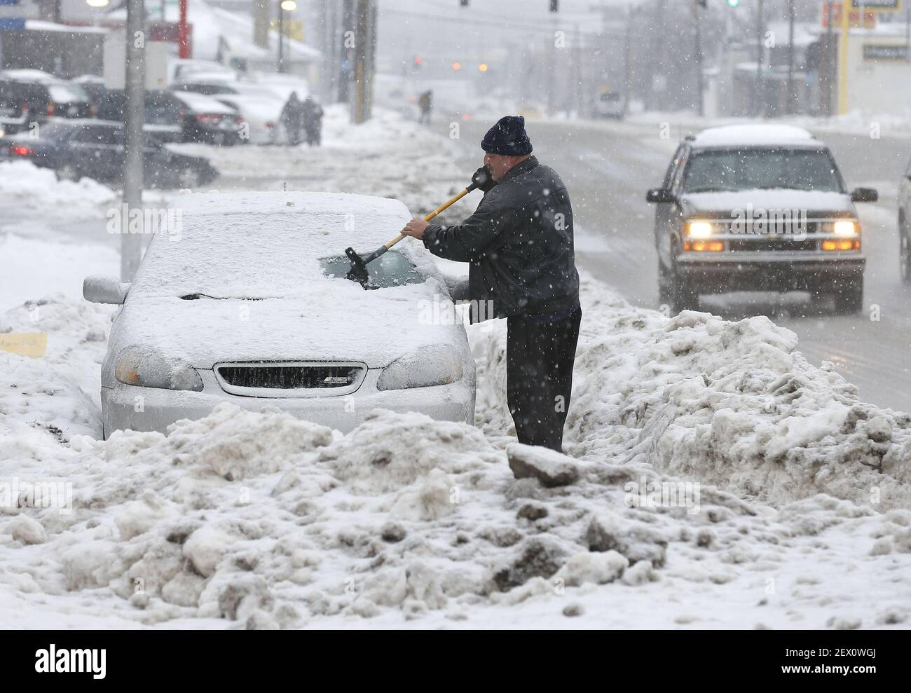 As snow continues to fall, Mohammed Jarboun cleans the new snow and ice off his car in Lexington, Ky., on Saturday, Feb. 21, 2015, as the third winter storm of the week to crosses Kentucky. (Photo by Charles Bertram/Lexington Herald-Leader/TNS) *** Please Use Credit from Credit Field *** Stock Photo