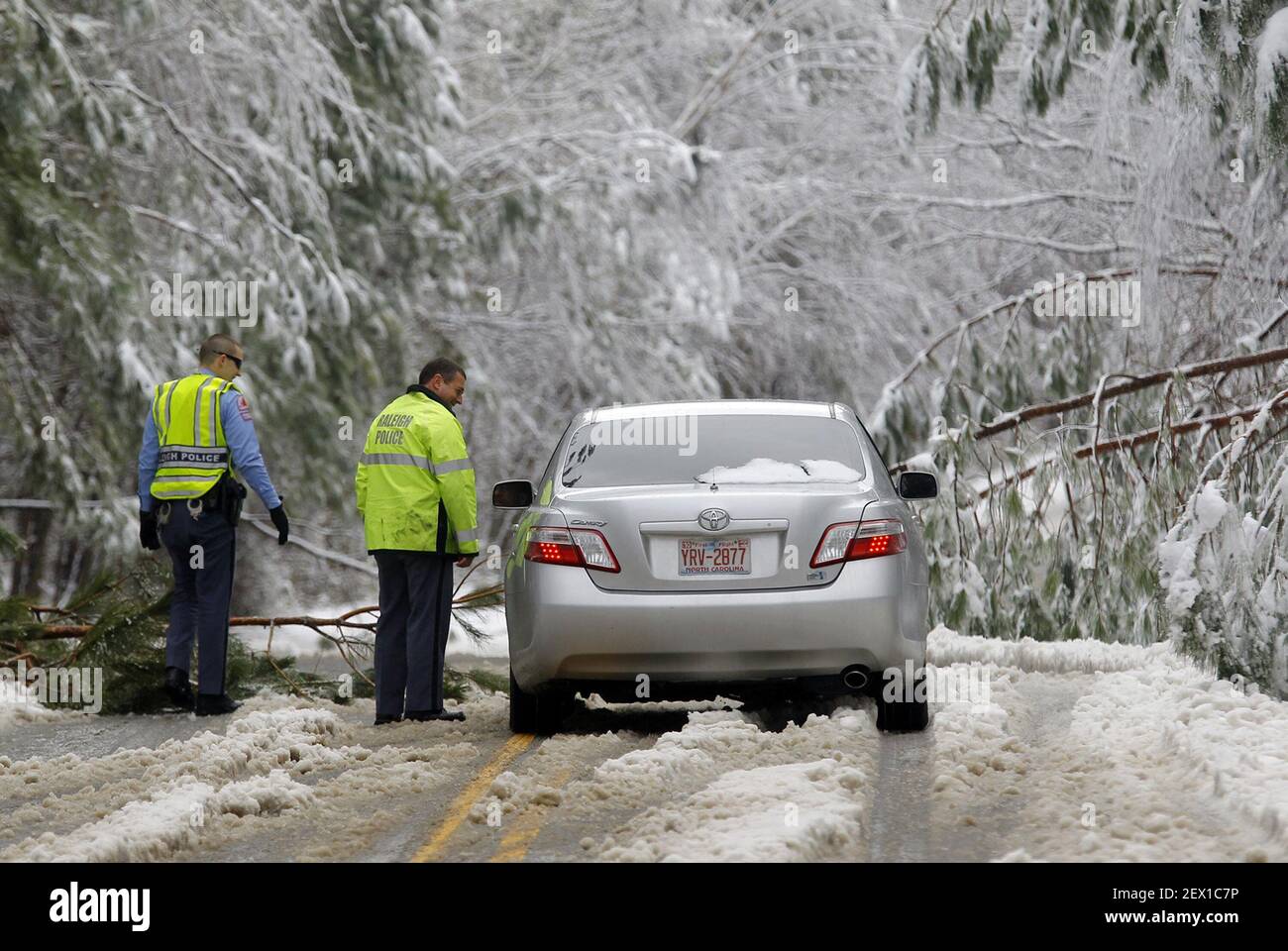 Raleigh Police Officer D.W. Sigrist, left, and Sgt. D.A. Morgan talk to a motorist trying to navigate through a road surrounded by ice-laden trees after a winter storm hit Raleigh, N.C., on Thursday, Feb. 26, 2015. Thousands were without power as a result of the power lines coming down. (Photo by Chris Seward/Raleigh News & Observer/TNS) *** Please Use Credit from Credit Field *** Stock Photo