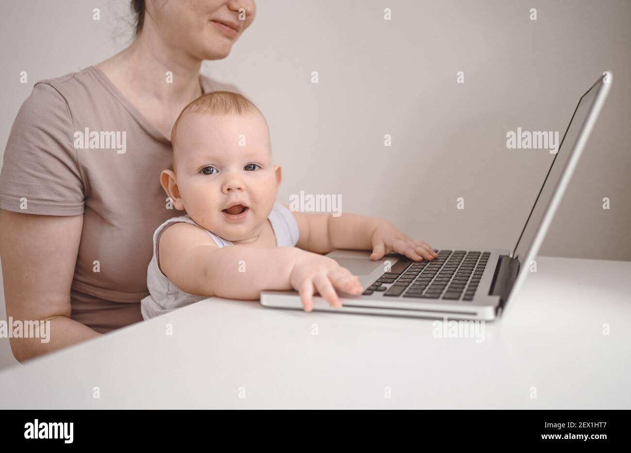 Close up portrait little baby boy funny facial expression sitting on  mother's lap studying laptop. Young mom work from home with computer. Home  office Stock Photo - Alamy