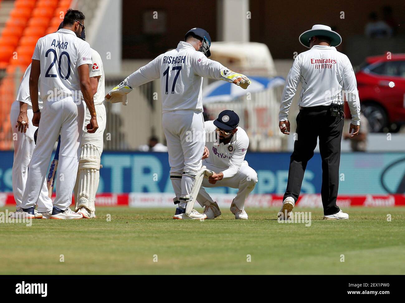 Cricket - Fourth Test - Narendra Modi Stadium, Ahmedabad, India - March 4, 2021. India's captain Virat Kohli checks the pads of wicketkeeper Rishabh Pant. REUTERS/Amit Dave Stock Photo