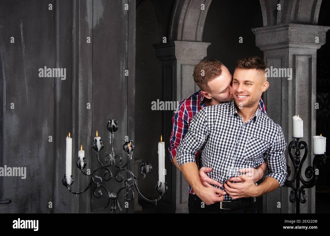 Young happy gay couple getting married in church. Love and romance. Handsome men in suits. Stock Photo