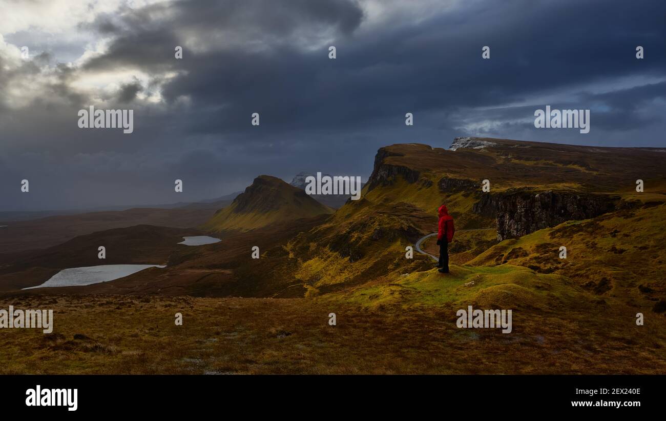 Looking over the high cliffs and plateaus at the Quiraing, skye Island, Scotland mountaineer with red jacket Stock Photo