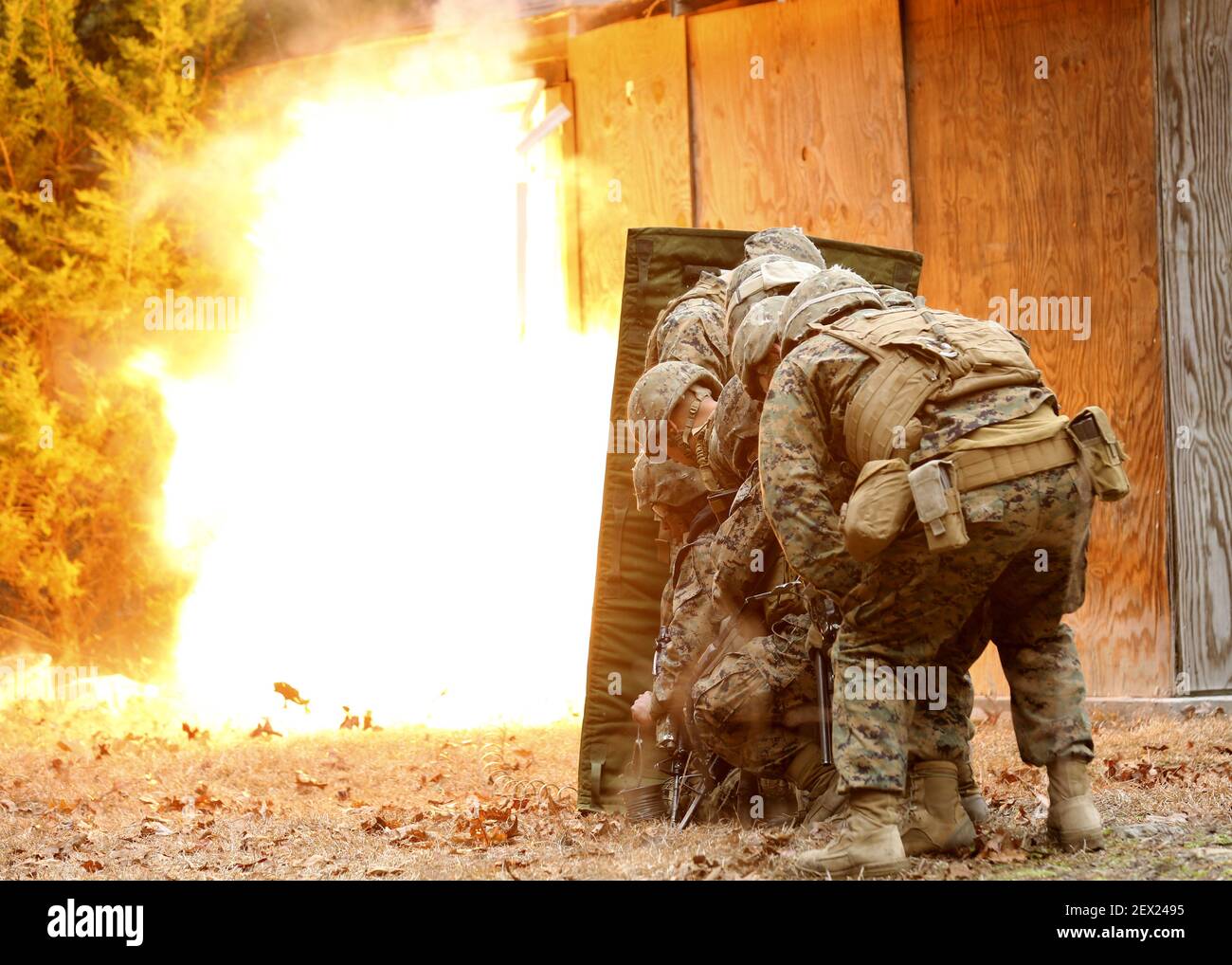 Marines with 2nd Marine Division stand behind a blast blanket as detonation cord ignites, blowing the door in and giving them a clear passage to breach the building during an urban breaching course, aboard Camp Lejeune, North Carolina, March 3, 2015. For each breach, the Marines would stack up behind a blast blanket, which allows them to stand closer to the blast by protecting them from shrapnel and debris. (Photo by Cpl. Justin T. Updegraff/U.S. Marine Corps) Stock Photo