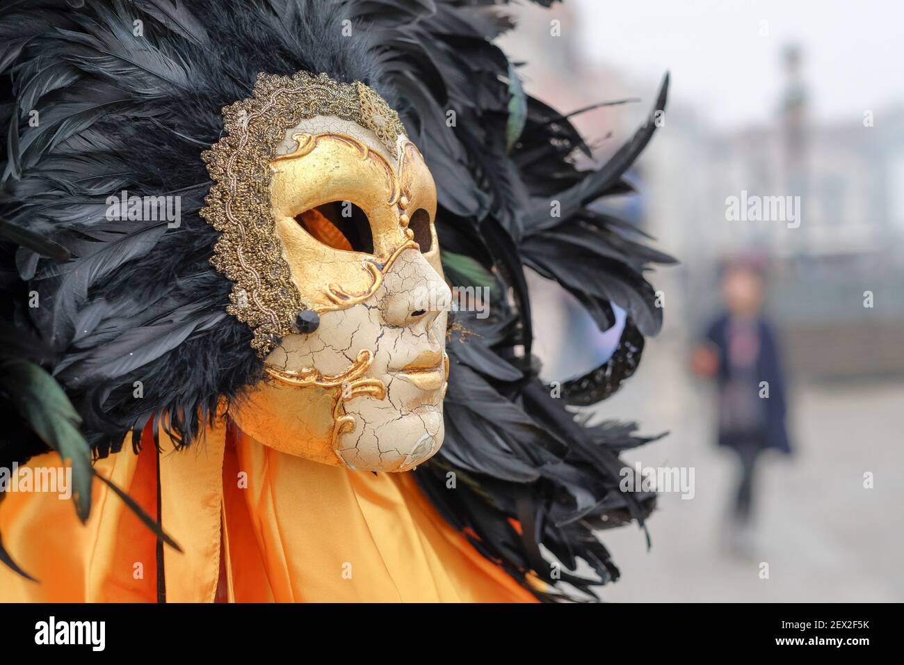Venetian Masquerade Mask, carnival mask on sale in Venice, Italy. Crackled porcelain face mask surrounded by a plume of black feathers Stock Photo