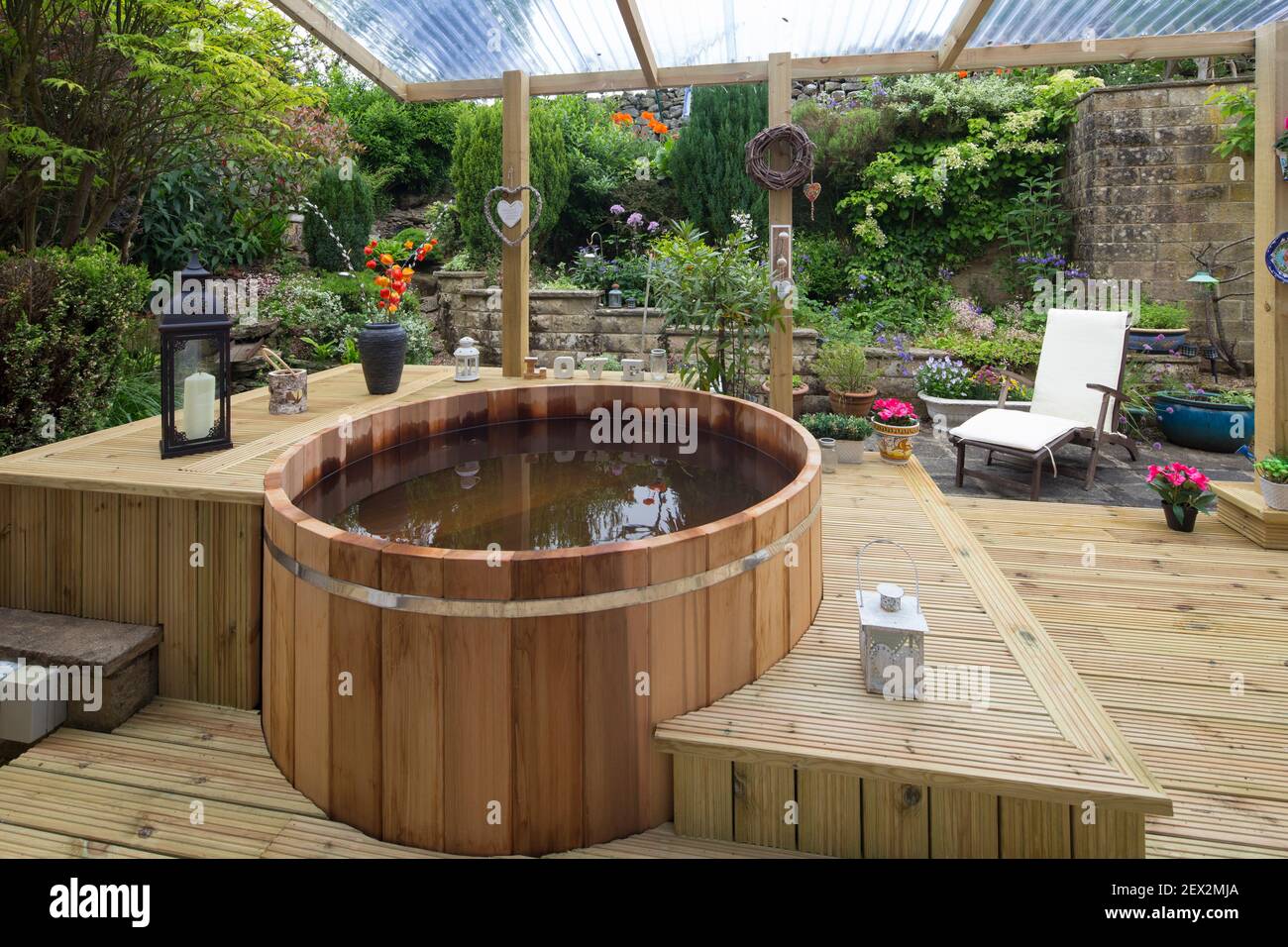 Wooden hot tub on outside decking area Stock Photo