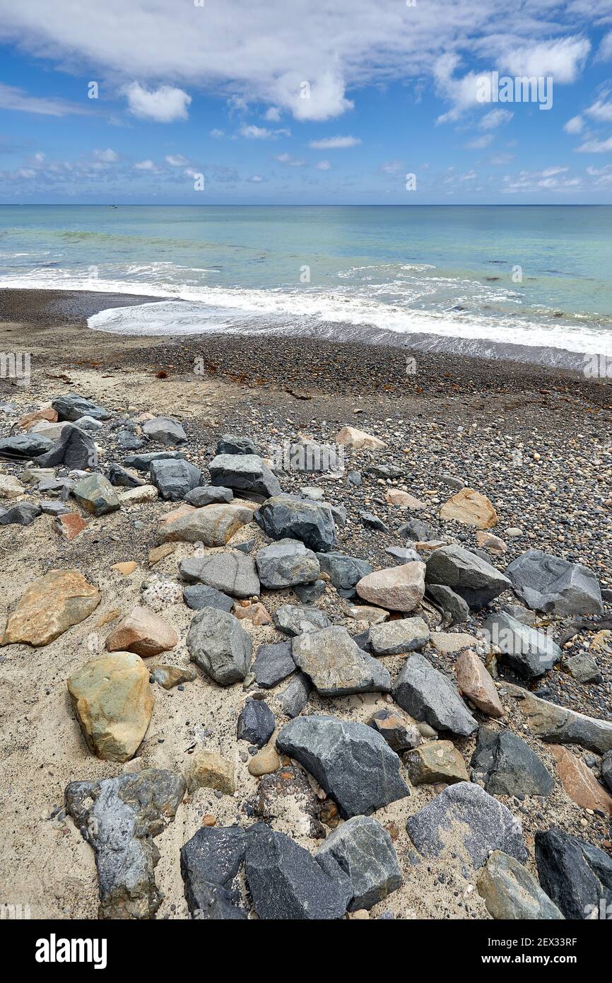 Rocky San Clemente California beach with blue sky and clouds and aqua ocean water, photo taken at low angle Stock Photo