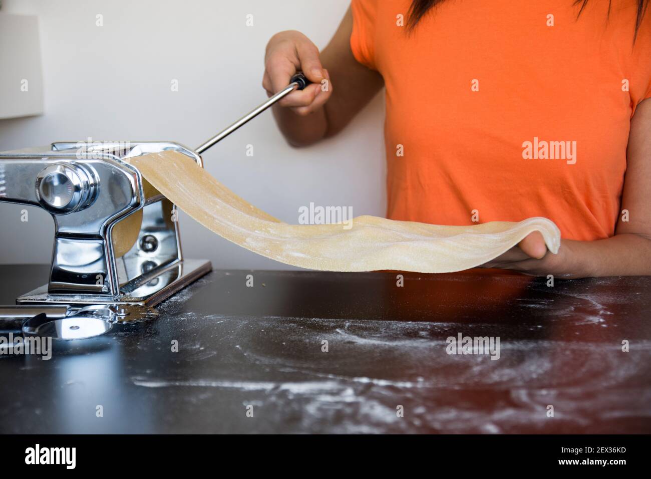 https://c8.alamy.com/comp/2EX36KD/preparing-homemade-fettuccine-on-pasta-machine-cutting-raw-dough-into-tagliatelle-on-special-equipment-traditional-italian-cuisine-concept-copy-spa-2EX36KD.jpg