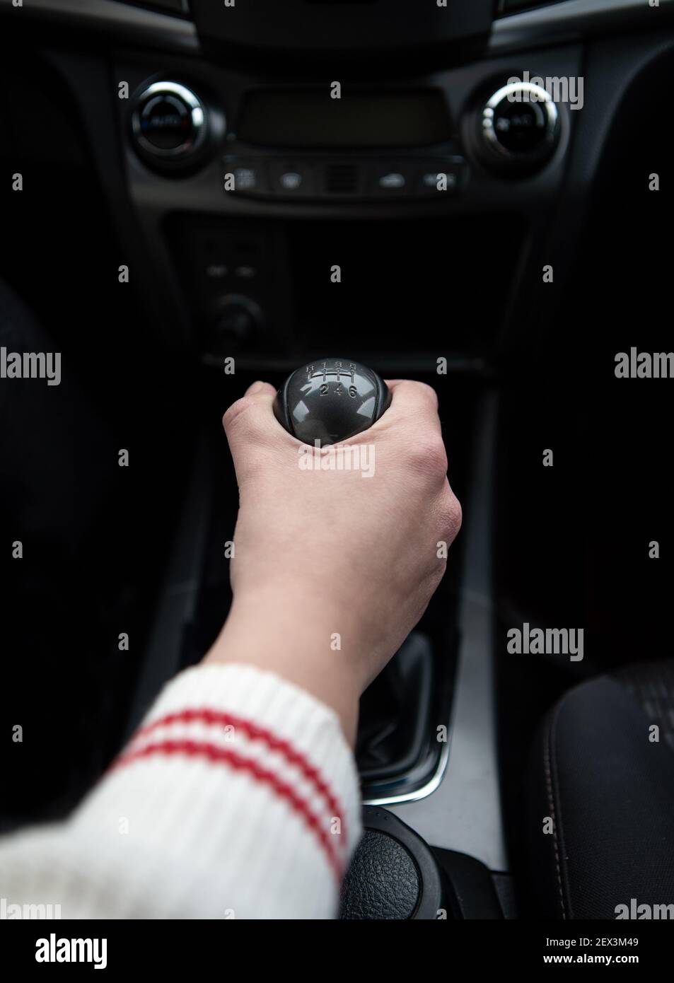 Person changing gears with the transmission gear shift stick of a car