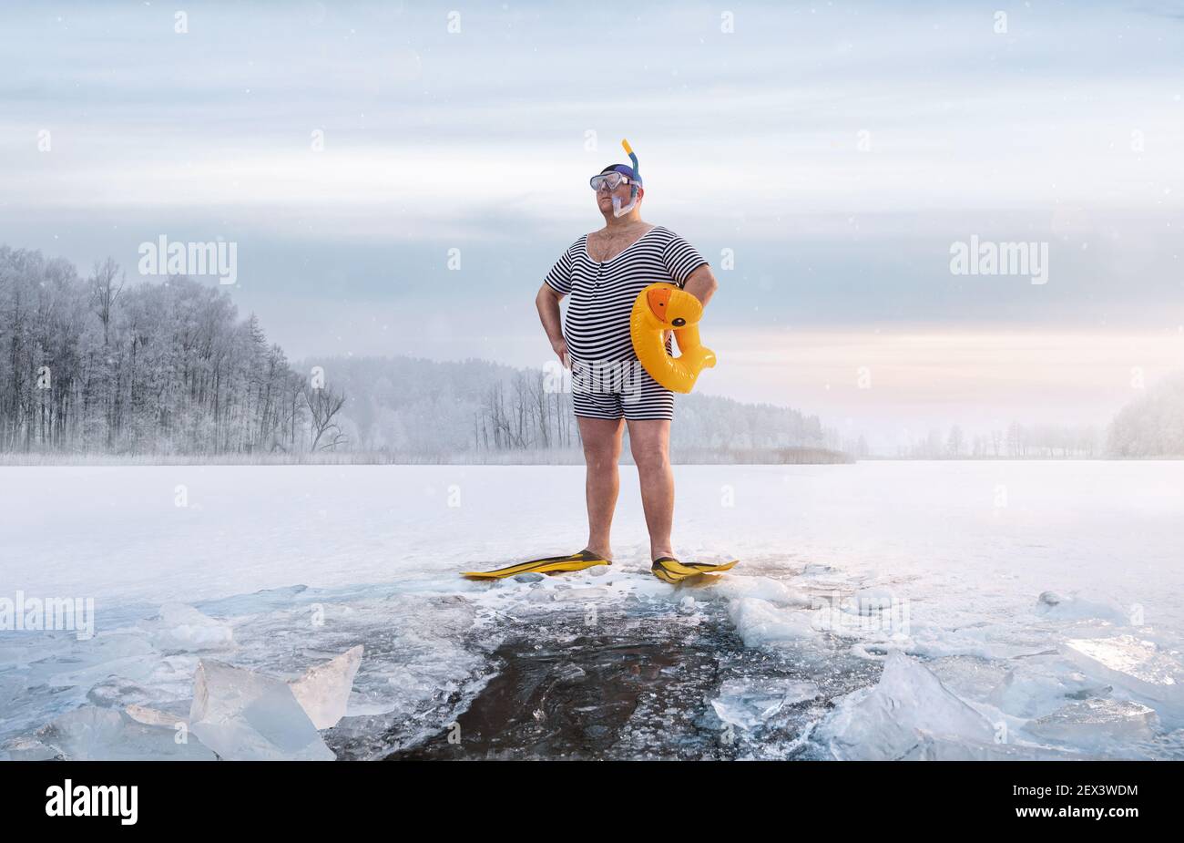 Fuunny overweight, retro swimmer standing by the ice hole in the lake, at the cold sunrise with copy space Stock Photo