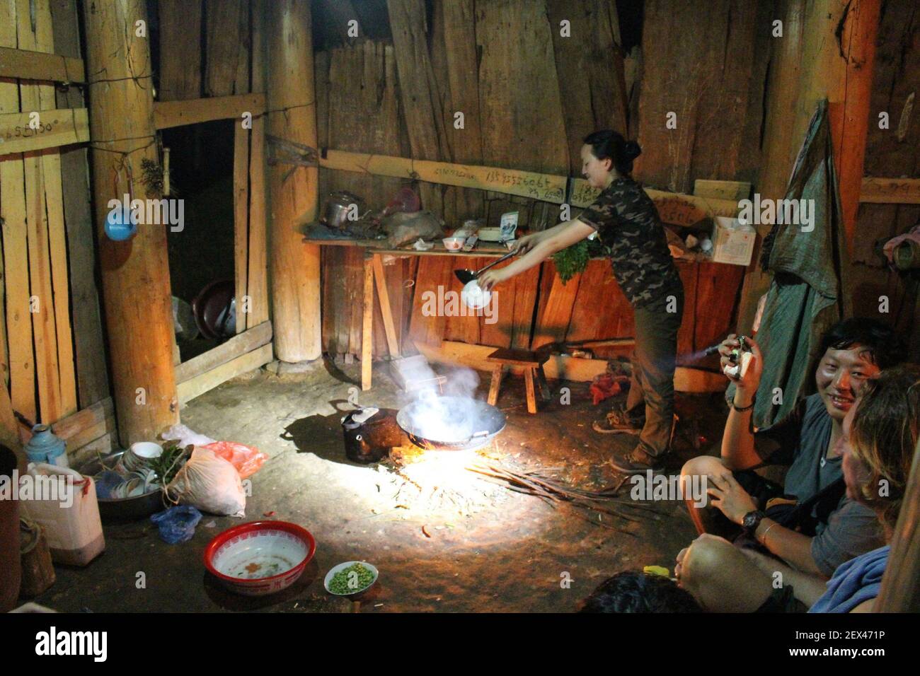 Wang Fang, a teacher and part-time tour guide, prepares dinner in a Miao farm house in the hills above Rongjiang in Guizhou province, China, on April 4, 2015. The Miao, who are related to the Hmong in other parts of Asia, typically cook over open fires, subsisting on rice, vegetables, tofu, salted pork, pickled fish and other local staples. Wang Fang's mother is Miao and her father is Dong, another ethnic group in this remote part of southern China. (Photo by Stuart Leavenworth/McClatchy DC/TNS) *** Please Use Credit from Credit Field *** Stock Photo